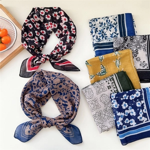 Variety of floral print silk scarves with paisley and polka dot patterns on white background
