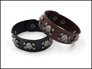 Detail of leather punk wristbands with skull studs and silver rivets in black and brown
