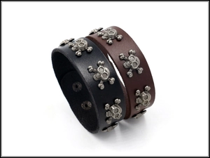 Detail of leather punk bracelets with silver skull studs in black and brown colors