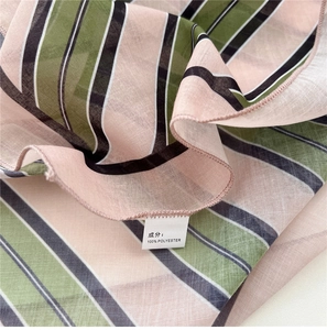 Vue macro du tissu rayé en polyester avec bords surjetés fins sur un foulard en soie