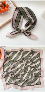 Vue détaillée d'un foulard en soie à rayures rose et vert olive montrant la texture