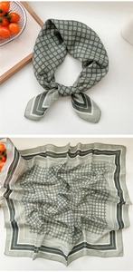 Détail d'un foulard en soie rétro vert clair avec motif de grille sur plateau en bois