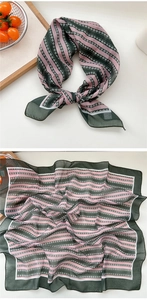 Détail d'un foulard en soie rayé vert et rose avec des motifs géométriques élégants
