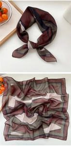 Détail d'un foulard vintage à rayures avec blocs géométriques bordeaux et tissu léger