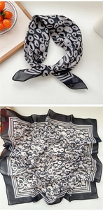 Détails d'un foulard en soie vintage montrant le motif léopard noir et blanc poli