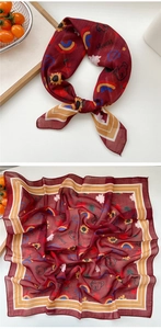 Détail macro d'un foulard carré rouge vin avec motifs de tournesol et imprimé floral