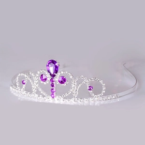 Macro detail of silver baroque crown with teardrop purple crystals and heart vine design