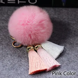 Gedetailleerde weergave van roze faux fur pompom sleutelhanger met drie kwastjes