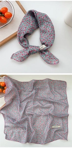 Detailed view of square paisley floral scarf with explore infinity label and red edging