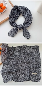 Detail of paisley cotton scarf featuring delicate lace edges and decorative woven label