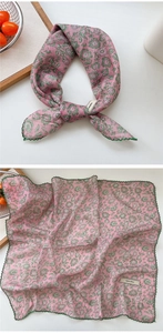 Detail of pink floral cotton scarf with green lace trim and branded woven label tag