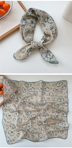Close-up of floral cotton scarf with green lace trim and explore infinity tag detail