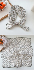 Close-up of cotton floral scarf featuring green lace trim and grid texture fabric