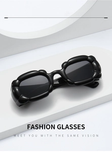 Detail of black wave-pattern resin frame sunglasses with dark lenses in Y2K style