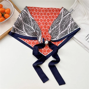 Vista macro dettagliata di un foulard elegante con stampa floreale e fibbia magnetica a perla