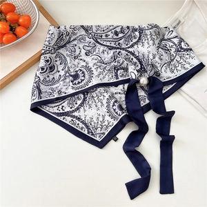 Dettaglio foulard in seta paisley con chiusura a perla magnetica e nastro blu navy