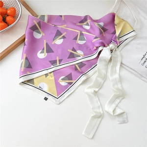 Dettaglio di foulard in seta geometrico con elegante fibbia magnetica a perla grande