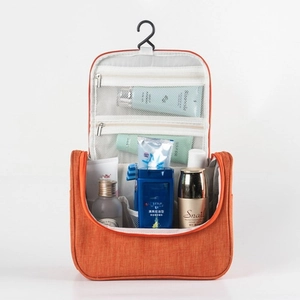 Orange hanging travel toiletry bag with multiple mesh pockets and waterproof fabric