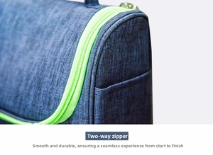 Detail of blue travel toiletry bag showing durable neon green dual zippers and fine texture