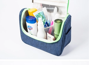 Detail view of large navy travel toiletry bag with green zippers and mesh compartments