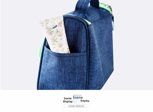 Detail of navy knit travel toiletry bag featuring side pocket and neon green zipper accents