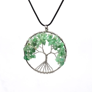 Macro shot of tree of life pendant with silver wire wrap and green stone inlay