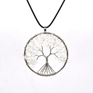 Detailed macro view of handmade tree of life pendant with white crystal and silver wire