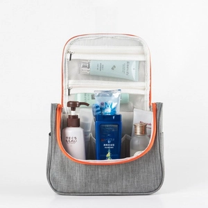Detail of grey travel toiletry bag featuring orange lining, hooks and multiple mesh pockets