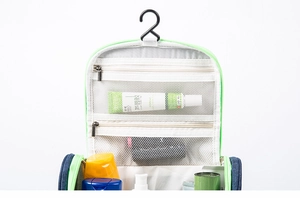 Detail of hanging toiletry bag with mesh pockets and hooks in green and navy blue
