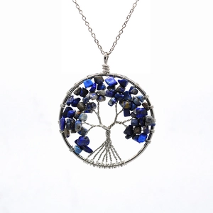 Detail of tree of life pendant with silver wire wrap and blue lapis lazuli stones
