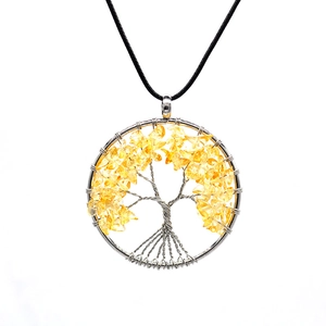 Detailed close-up of tree of life pendant with yellow crystals and silver wire wrap