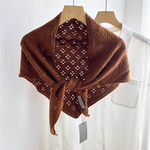 Detailed view of dark brown openwork knit texture on a triangular shawl wrap scarf