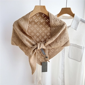 Detail of khaki hollow knit triangle shawl with ribbed edges and elegant texture
