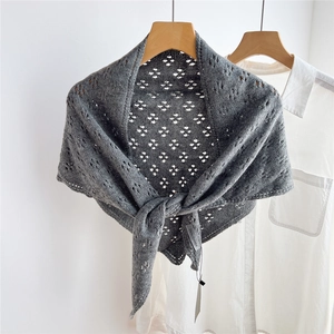 Detailed knit pattern of grey crochet shawl featuring delicate hollow diamond weave texture
