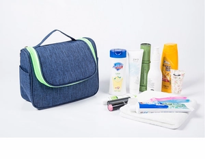 Blue hanging travel toiletry bag with mesh side pockets and vibrant green zippers