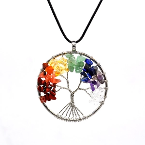 Macro shot of silver wire tree of life pendant with colorful natural stone chips