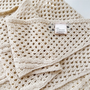 Detailed close-up showing the hollow knit pattern and merino wool blend material