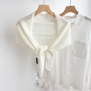 Close-up of white crochet hollow triangle shawl featuring intricate knit patterns
