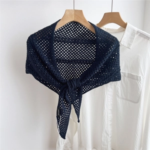 Detail showing the intricate hollow crochet texture of the black knitted triangle shawl