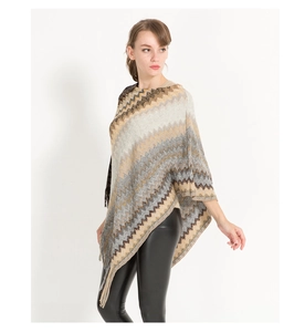 Detail of autumn knit poncho cape with brown beige wave pattern and fringe hem