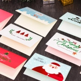 Flat lay of vintage Christmas cards with Santa and reindeer motifs on a dark wood table
