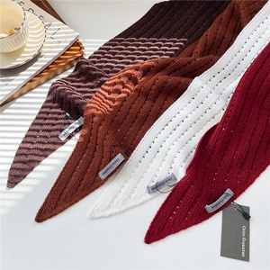 Detail of hollow knit triangle scarves in brown, caramel, white and wine red colors