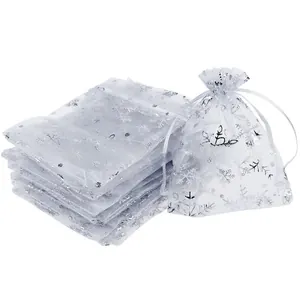 Detailed view of white organza gift bags with silver snowflake print and drawstring closure