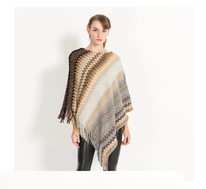 Detail shot of knitting pattern and tassel hem on autumn striped poncho sweater
