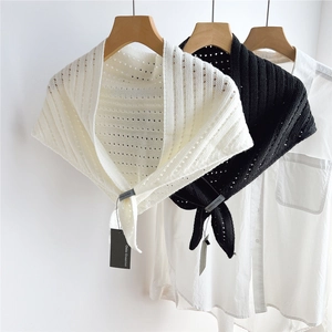 Detail of striped knitted hollow shawl with vertical textures and white shirt layering