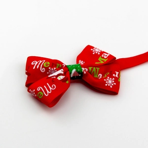 Detail of red Christmas pet bowtie with Merry Christmas text and snowflake patterns