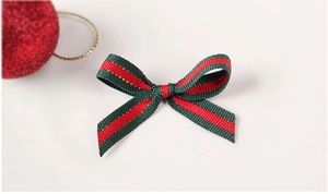 Nœud de ruban de Noël vert et rouge avec coutures dorées sur fond blanc