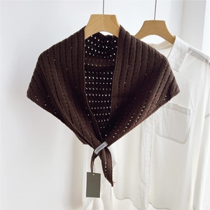 Detail of dark coffee knitted shawl with hollow point pattern over white shirt
