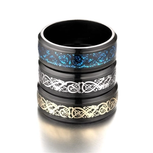 Dettaglio di tre anelli in titanio nero con intarsi di drago nei colori blu, argento e oro