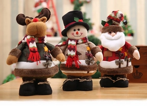 Three plush Christmas figurines featuring Santa, snowman and reindeer on wooden surface